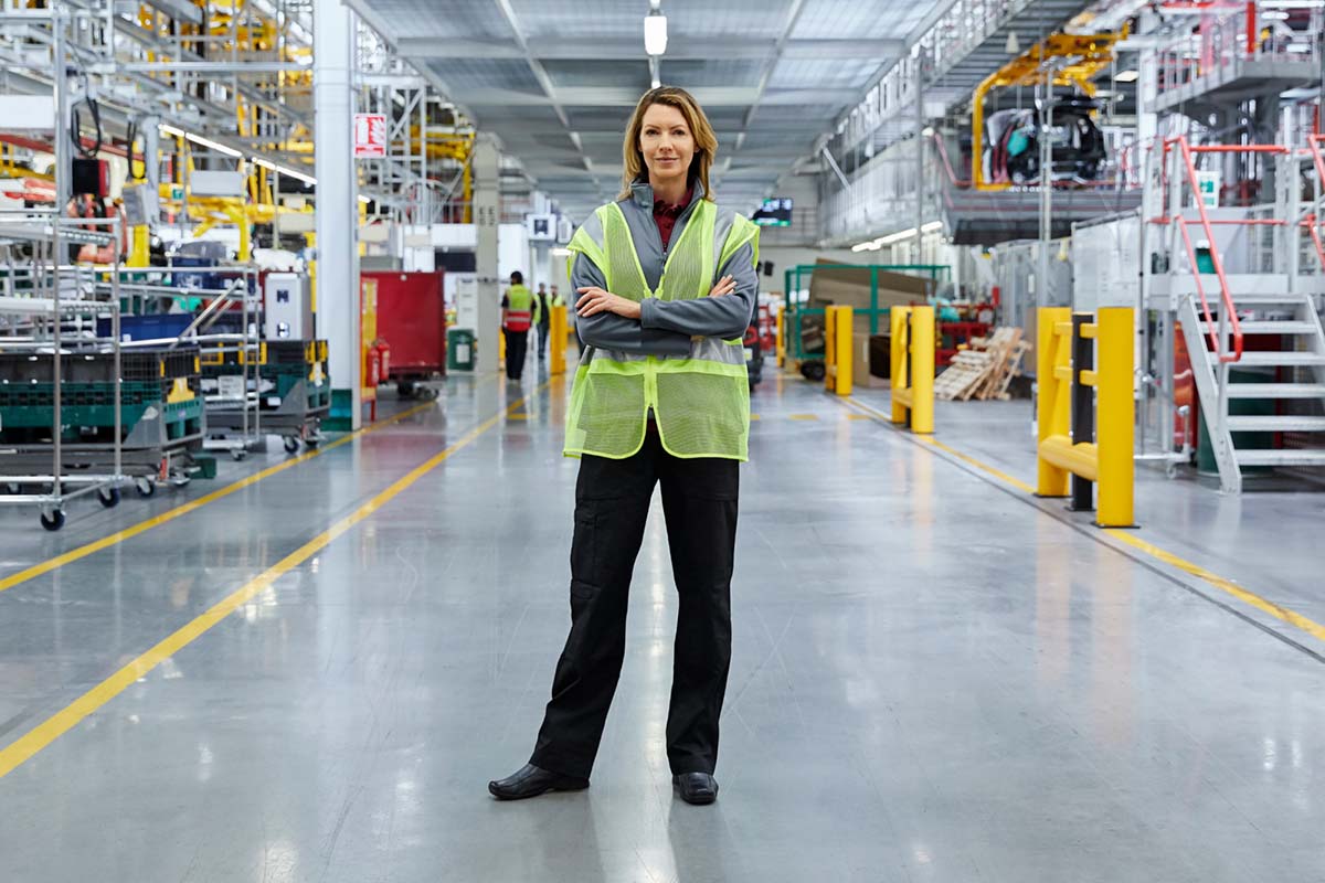 Vrouw in lichtgevend veiligheidshesje in een fabriek