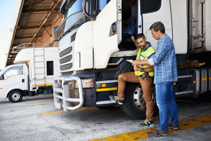 Truck driver about to get in his truck is talking with a colleague